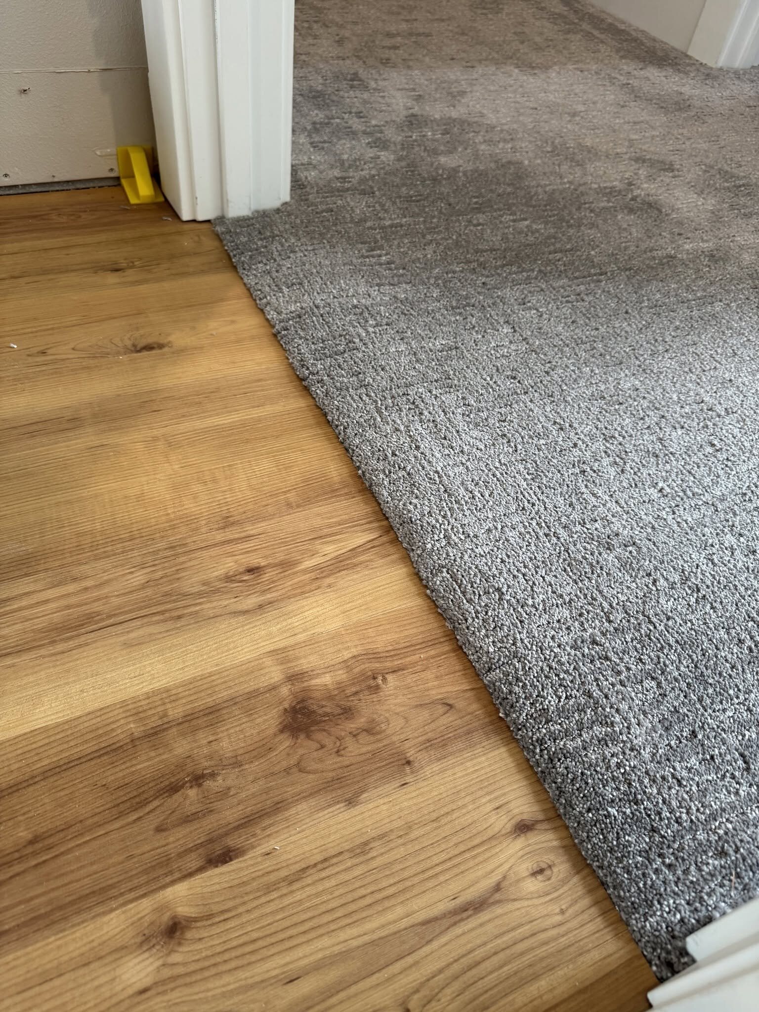 Clean carpet to luxury vinyl plank transition detail by MG Flooring